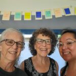 Seattle Insight - Alice, Sue and Sooz hanging blessing flags